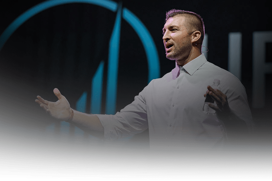 Tim Tebow on the stage speaking at a Life Surge Event